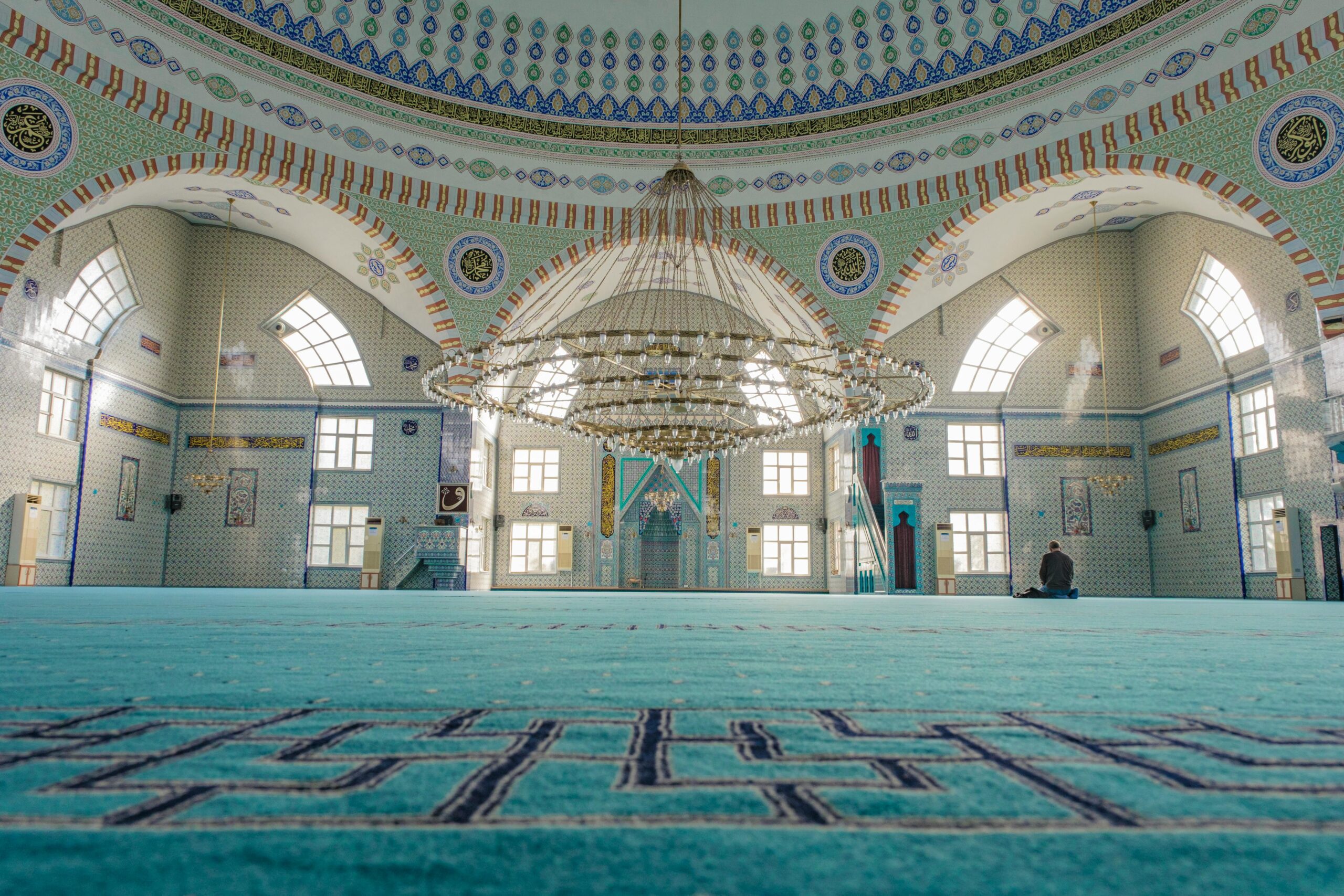 Stunning interior of a mosque in Bursa, TΓΌrkiye, featuring a grand chandelier and intricate design.