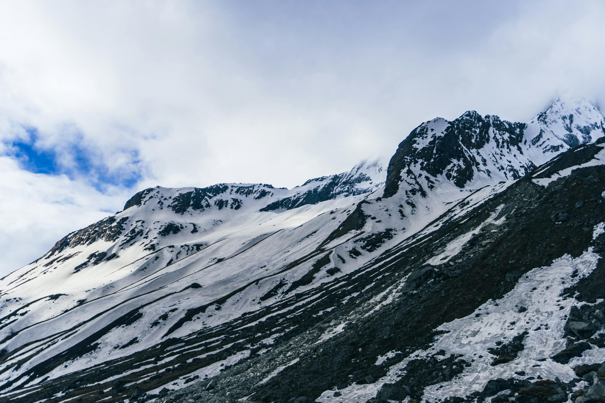 Majestic snow-covered mountain peaks against a bright blue sky, perfect for adventure enthusiasts.