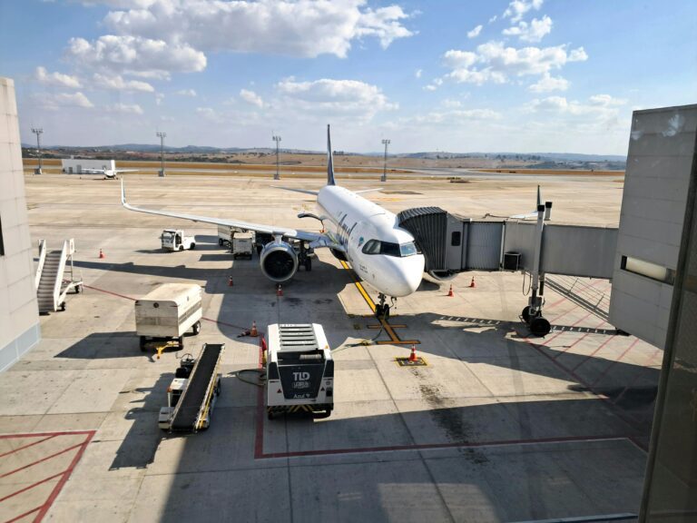 A commercial jet at a gate in Belo Horizonte, Brazil, under clear skies.